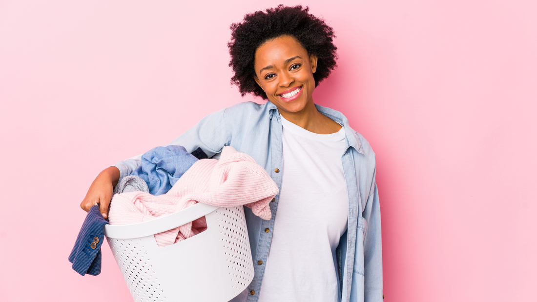 woman smiling and holding a basket of laundry